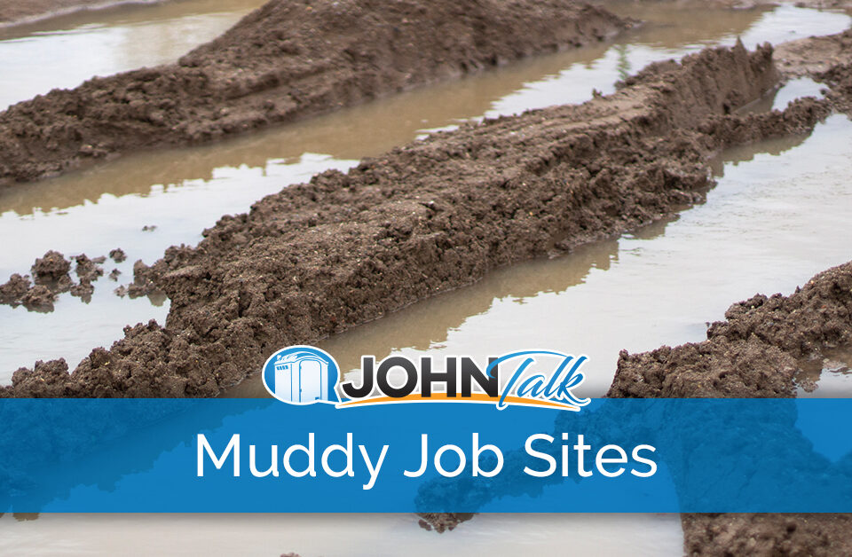 Closeup of muddy tire tracks and water at a job site