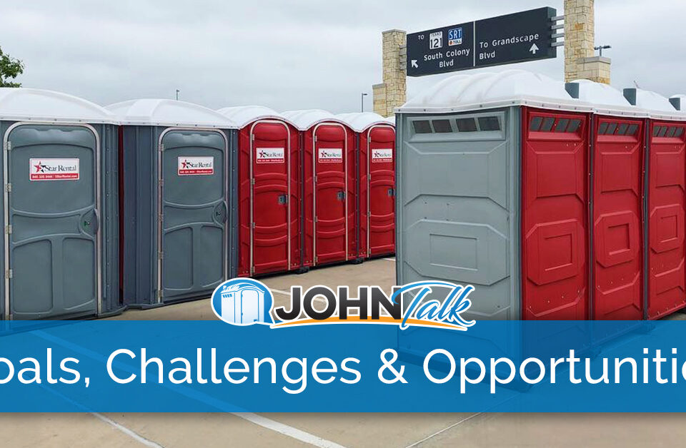 Rows of red and gray portable toilets at an event