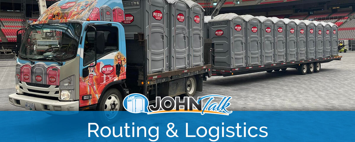 A colorful truck pulling a trailer loaded with several gray portable toilets inside a stadium