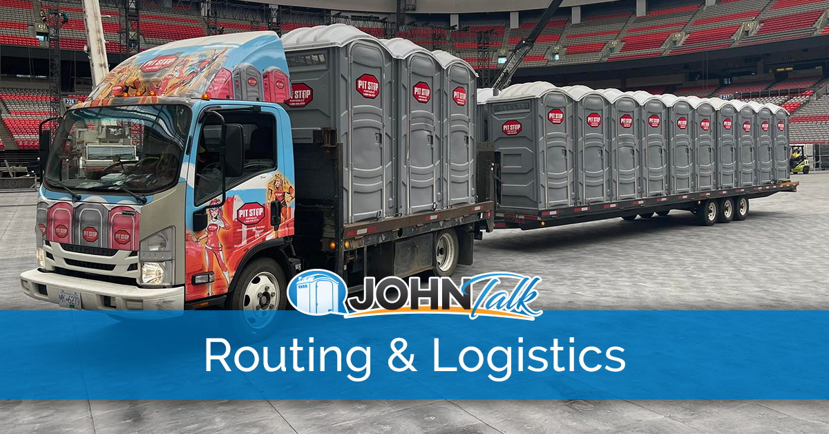 A colorful truck pulling a trailer loaded with several gray portable toilets inside a stadium