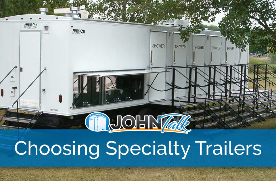 A large, white portable shower trailer