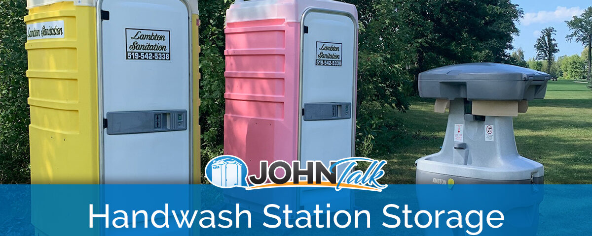 A portable handwash station and two portable toilets, one yellow and white and one pink and white, in a lush, green setting