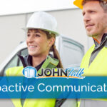 Two workers wearing hard hats and high-vis vests with a truck in the background