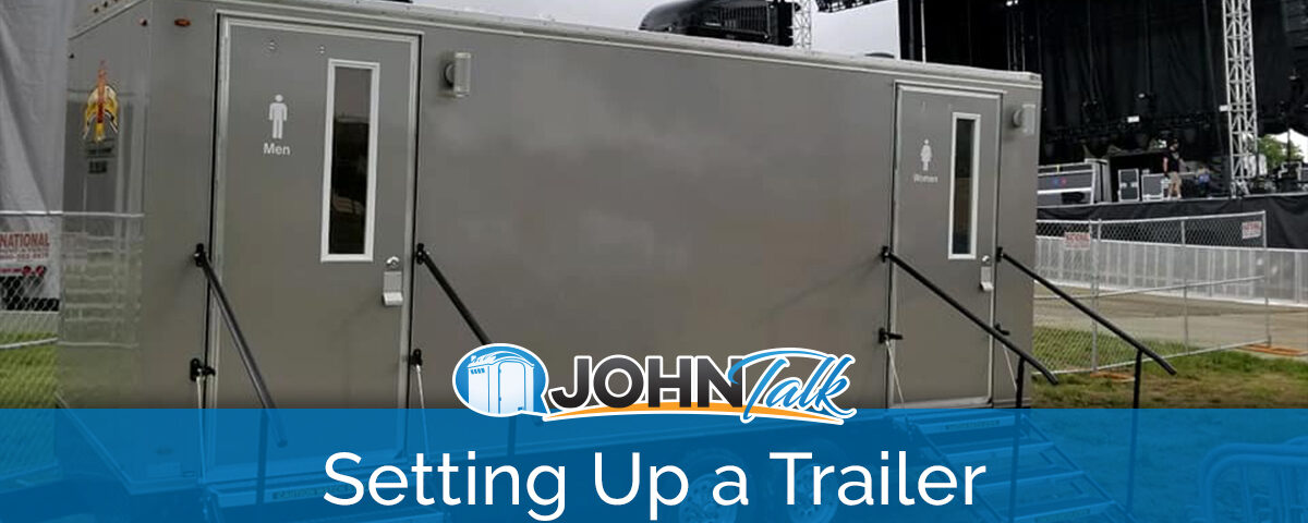 A portable restroom trailer at an outdoor concert venue