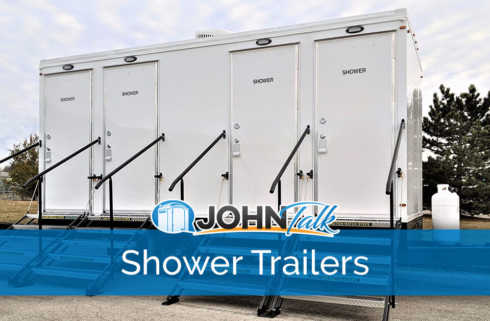 A white, four-door portable shower trailer